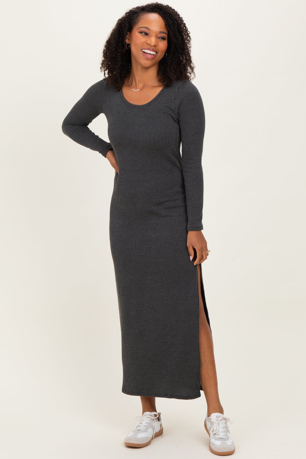 woman wearing a dark gray long sleeve ribbed maxi dress with side slits and sneakers