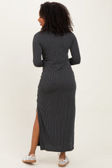 woman wearing a black ribbed maxi dress with long sleeves and a side slit, facing away from the camera