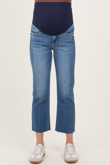 woman wearing a pair of light blue cropped maternity jeans with a navy over-the-bump panel and frayed hems