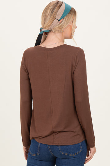 woman wearing a brown long sleeve top with a relaxed fit and scoop back, styled with a colorful scarf in her hair
