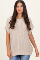 woman wearing a beige oversized knitted sweater with short sleeves and a relaxed fit