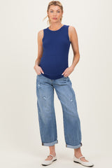 woman wearing a navy blue ribbed maternity tank top and distressed rolled-up jeans with a visible baby bump