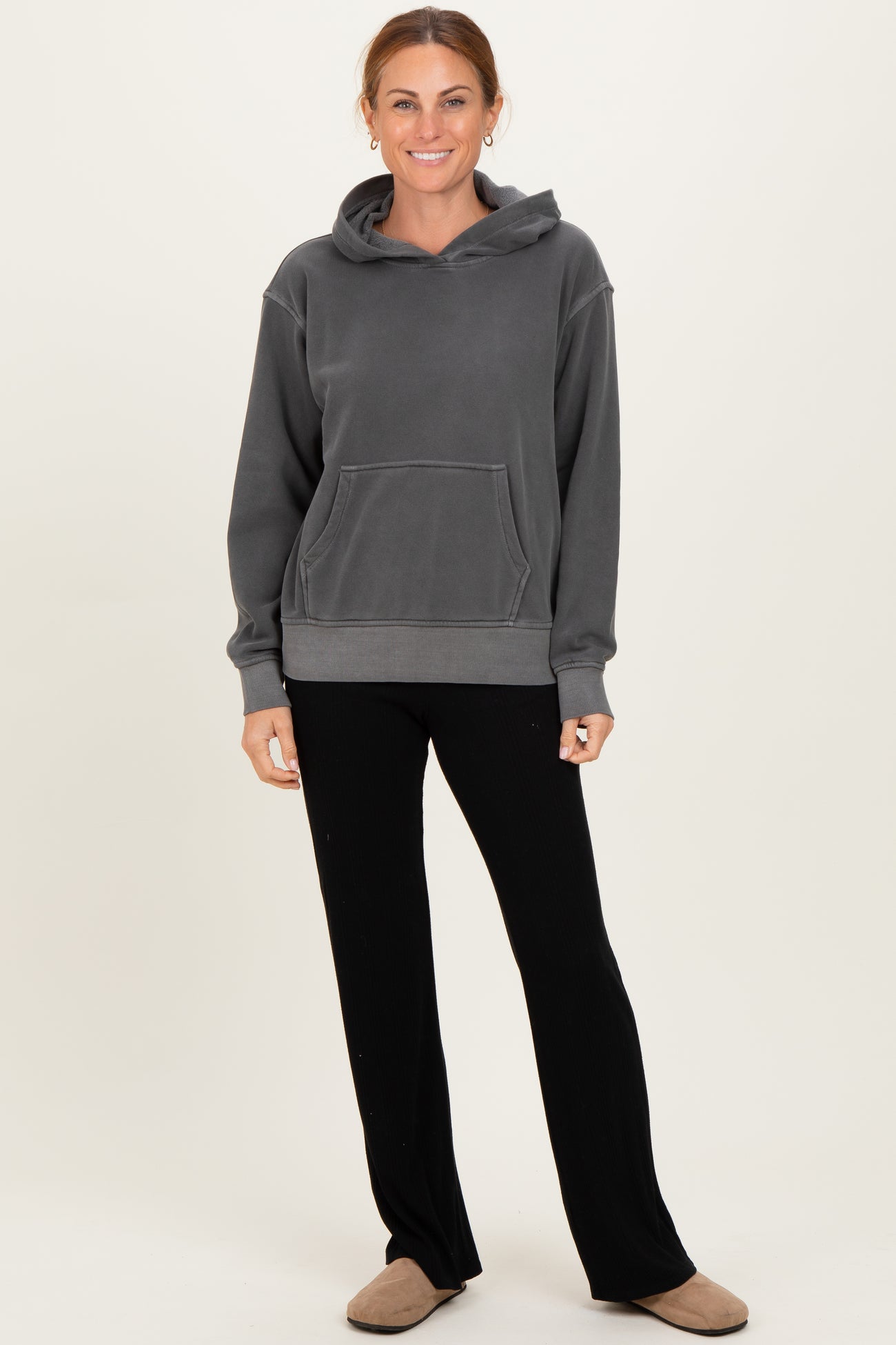 woman wearing a gray hoodie with a front pocket and black wide-leg pants
