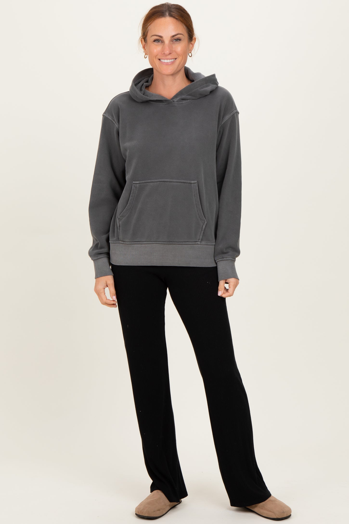 woman wearing a gray hoodie with a front pocket and black wide-leg pants
