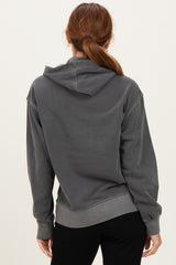 woman wearing a dark gray oversized hoodie with a hood and ribbed hem, shown from the back