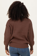 woman wearing a brown oversized sweater with dropped shoulders and ribbed hem, seen from the back