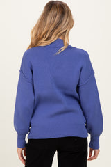 woman wearing a blue long sleeve maternity sweater with a relaxed fit, shown from the back