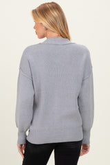 woman wearing a gray maternity sweater with balloon sleeves, seen from the back