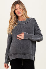 woman wearing a gray striped maternity sweater and holding her baby bump