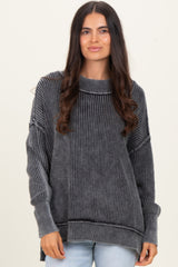 woman wearing a black and gray striped oversized sweater with a ribbed texture and relaxed fit