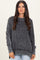 woman wearing a black and gray striped oversized sweater with a ribbed texture and relaxed fit