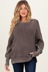 woman wearing a gray ribbed maternity sweater with a relaxed fit and long sleeves, holding her baby bump
