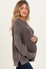 woman wearing a brown ribbed maternity sweater, showing her baby bump with long sleeves and side slits