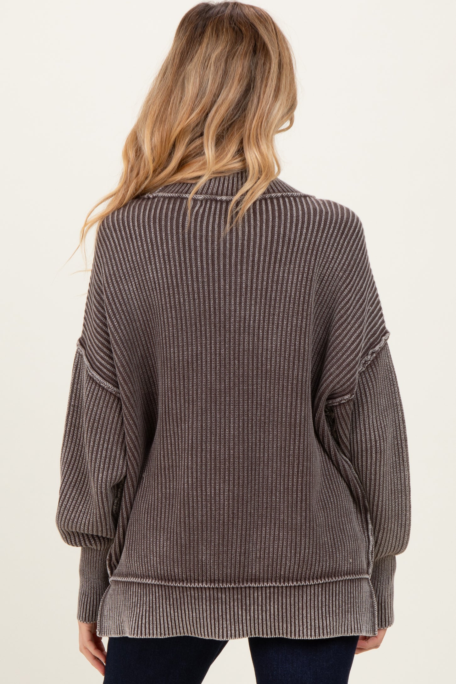 woman wearing a brown striped oversized maternity sweater, view from the back