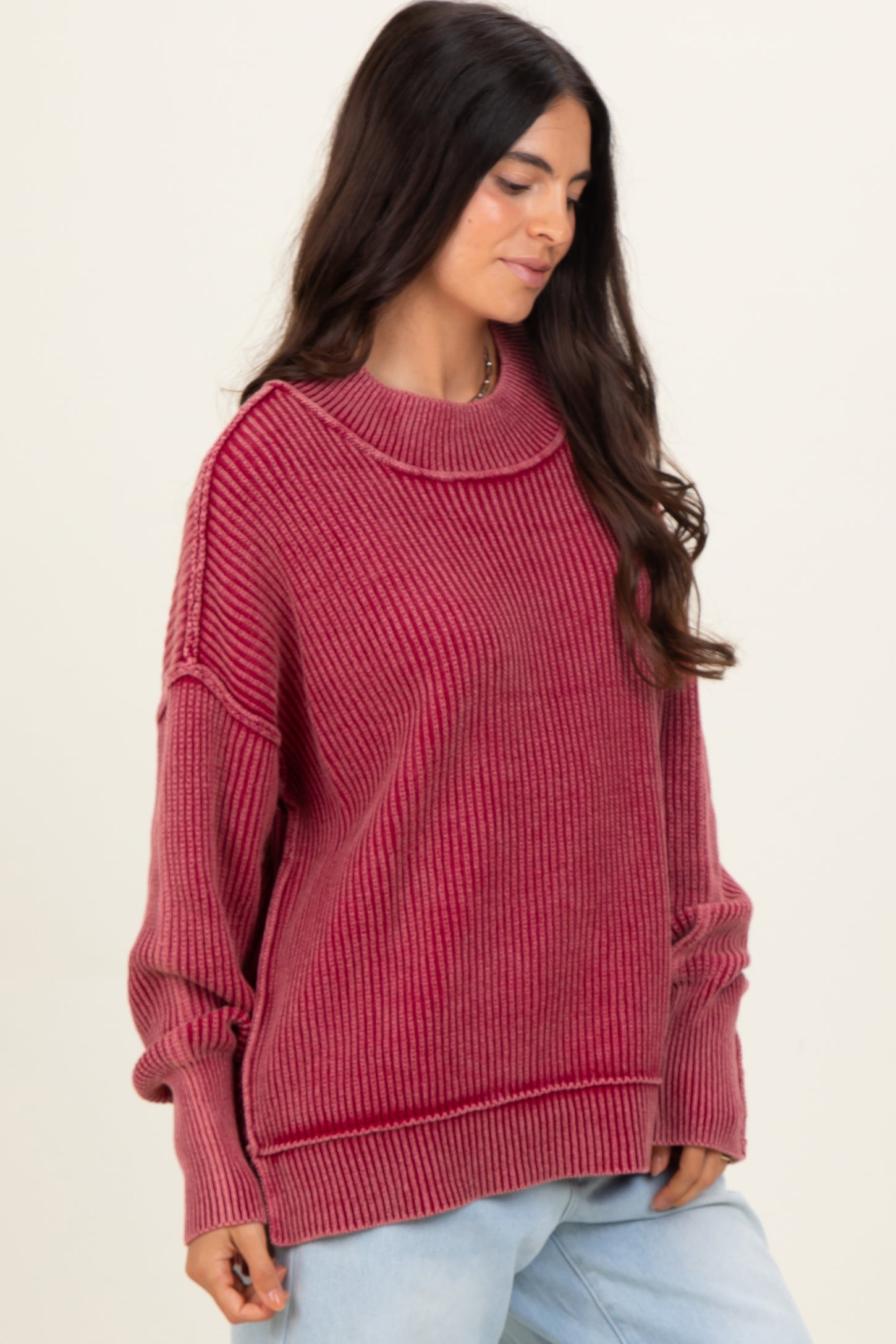 woman wearing a maroon ribbed oversized sweater with a relaxed fit and long sleeves