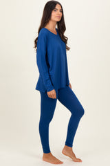 woman wearing a navy blue long sleeve top and matching leggings, standing sideways with a relaxed fit