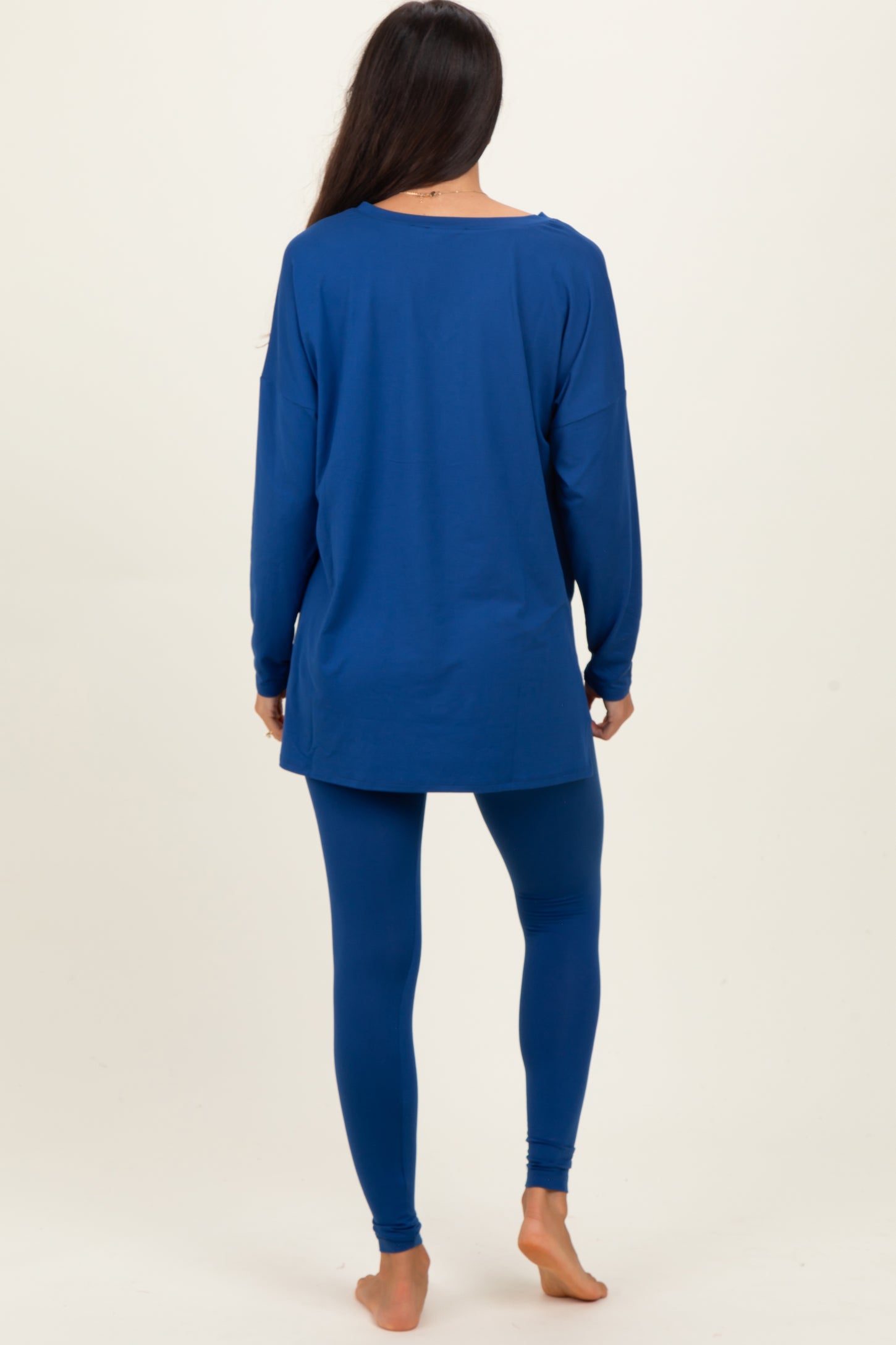woman wearing a long sleeve blue tunic and matching blue leggings, seen from the back