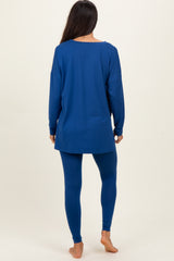 woman wearing a long sleeve blue tunic and matching blue leggings, seen from the back