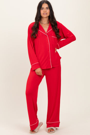 woman wearing a red long sleeve pajama set with white piping details and loose-fitting pants