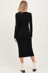 woman wearing a black long sleeve maternity dress with a fitted silhouette and knee-length hem