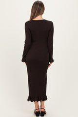 woman wearing a black long sleeve maternity maxi dress with ruffled hem and back detail