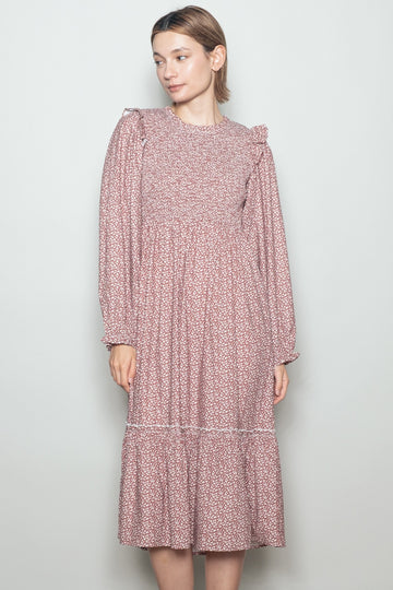 woman wearing a pink floral long sleeve dress with ruffle details and a tiered skirt