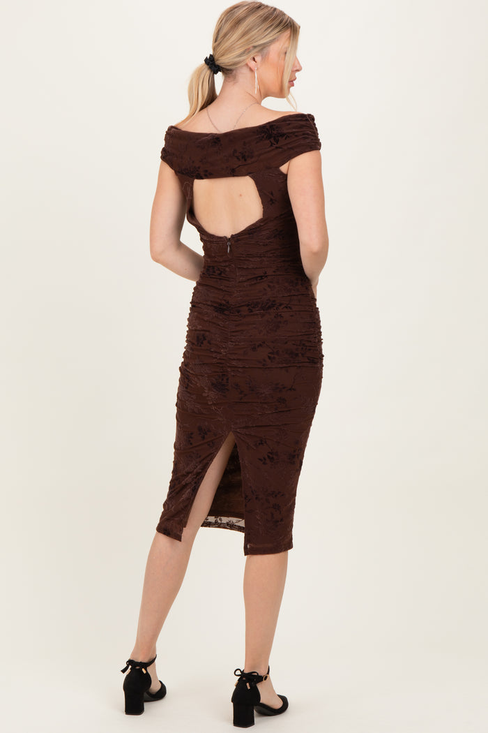 woman wearing a brown ruched midi dress with an open back and side slit, styled with black block-heel sandals