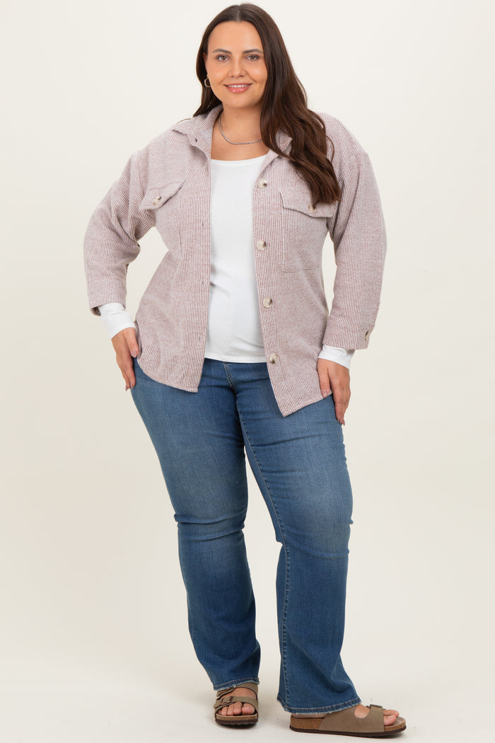 woman wearing a striped oversized shirt with front pockets and a white top, paired with blue flared jeans and sandals