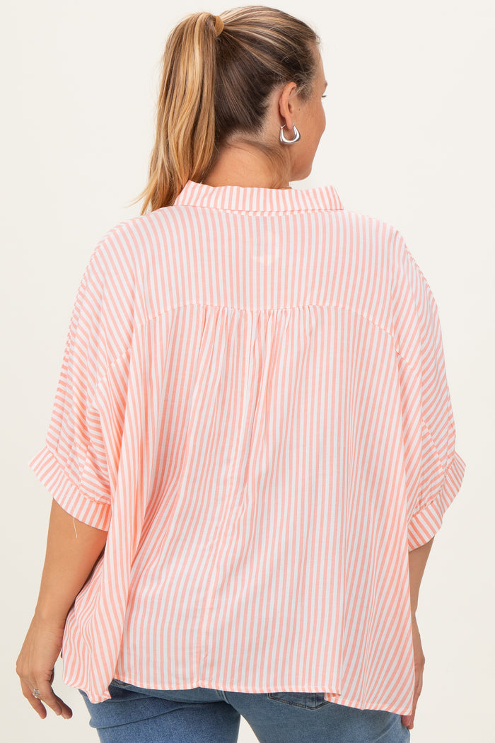 woman wearing a pink and white striped maternity plus oversized shirt, showing a relaxed fit from the back