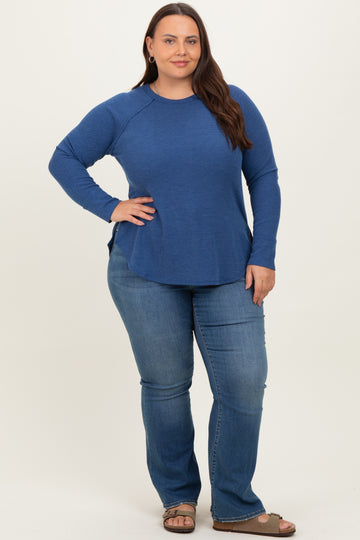woman wearing a long sleeve blue textured top with side slits and paired with light blue flared jeans