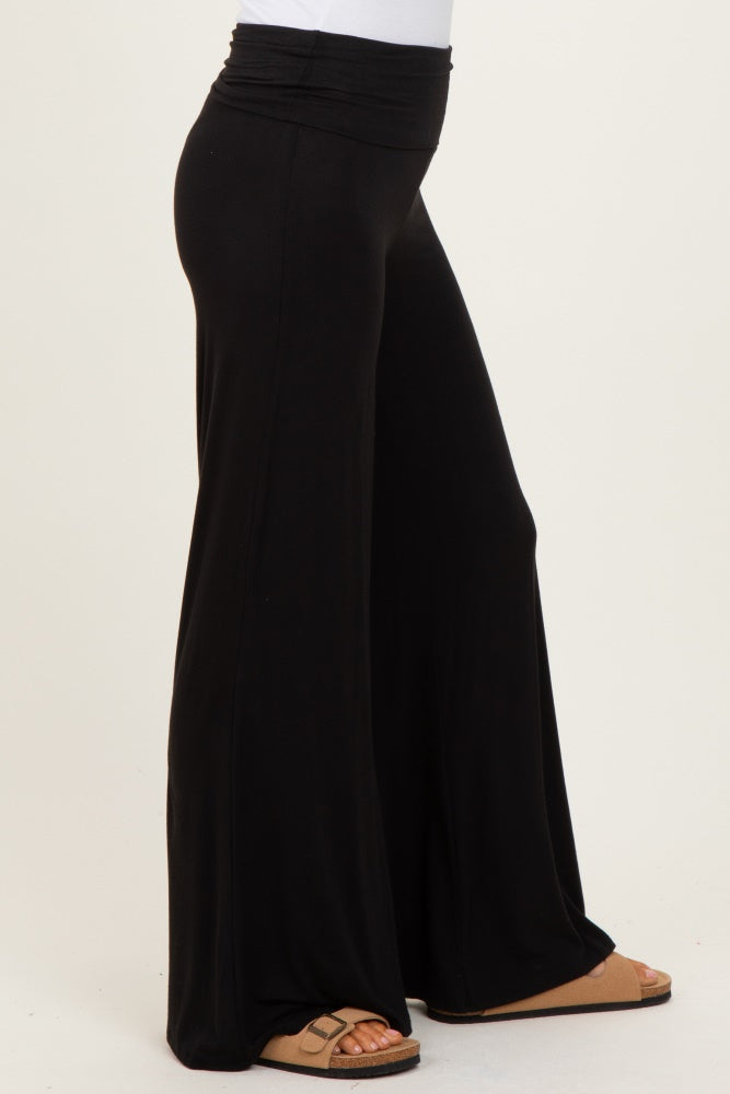 woman wearing black wide-leg lounge pants with a high waistband and sandals