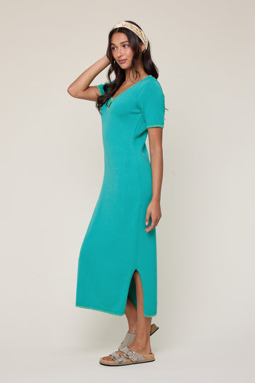 woman wearing a teal short sleeve maxi dress with side slits and a relaxed fit