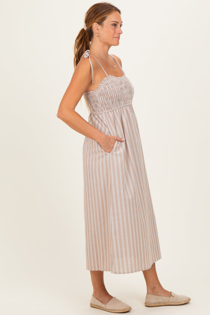 woman wearing a striped midi dress with adjustable straps and side pockets