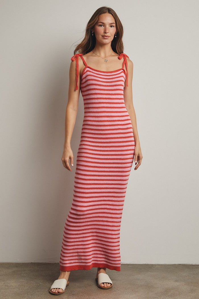 woman wearing a red and white striped maxi dress with tie straps and a fitted silhouette