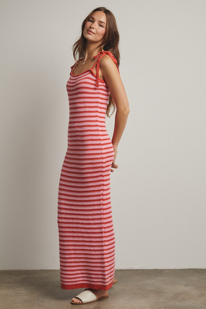 woman wearing a red and white striped sleeveless maxi dress with tie straps and a fitted silhouette
