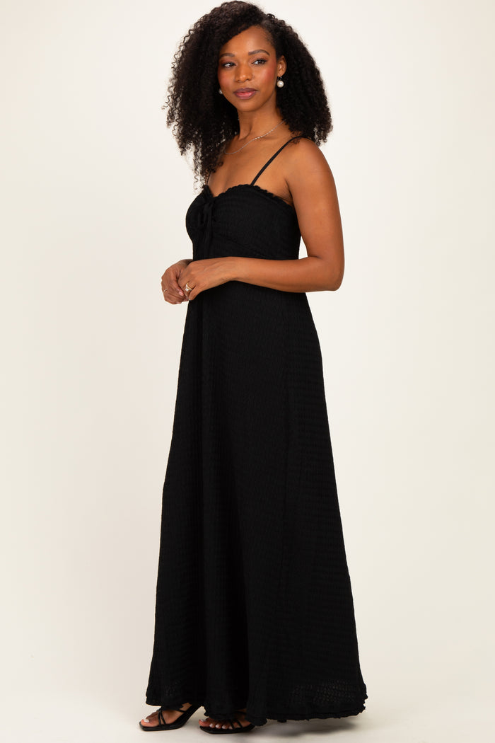 woman wearing a black long maxi dress with spaghetti straps and a tie front detail