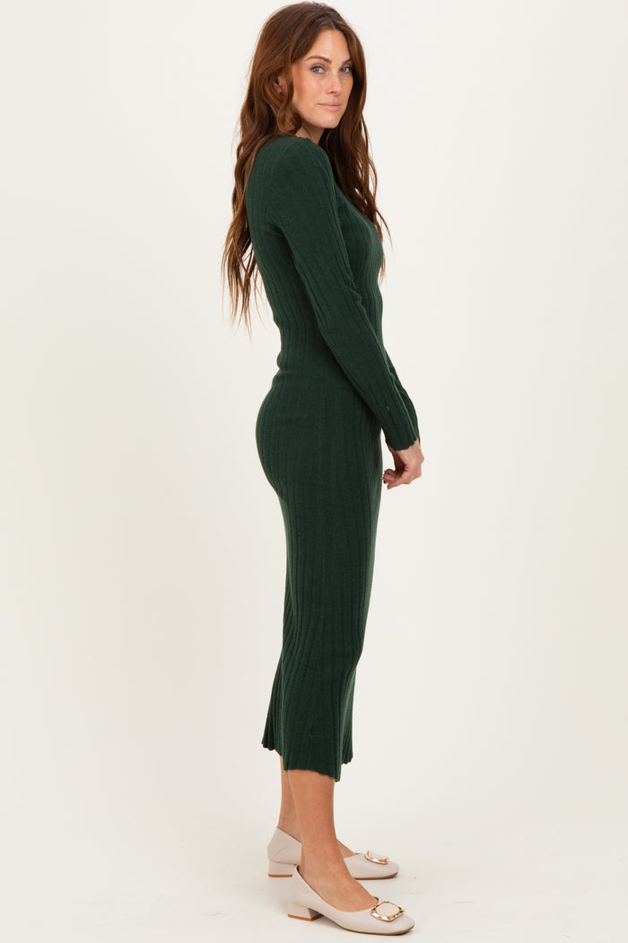 woman wearing a forest green ribbed midi dress with long sleeves and a fitted silhouette