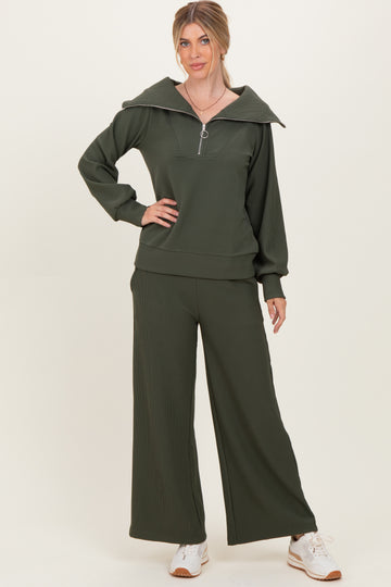 woman wearing a dark green ribbed zip-up sweatshirt and matching wide-leg pants with a relaxed fit
