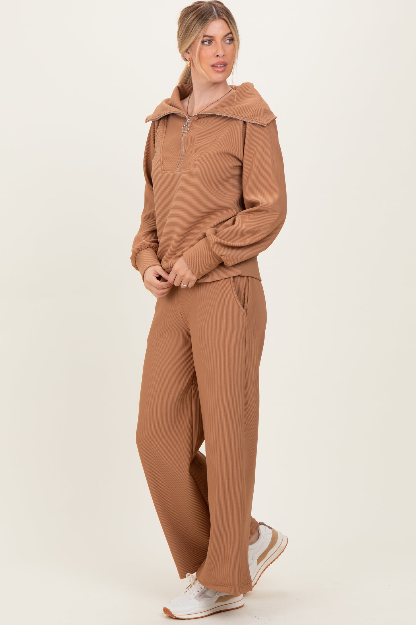 woman wearing a brown ribbed two-piece loungewear set with a zip-up hoodie and wide-leg pants
