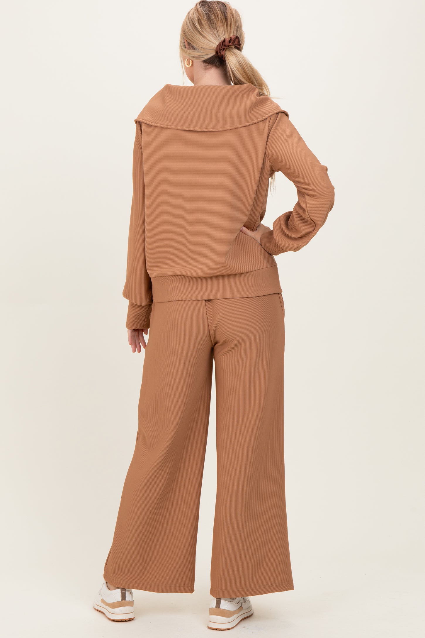 woman wearing a brown ribbed two-piece outfit with a stylish off-shoulder top and wide-leg pants from the back