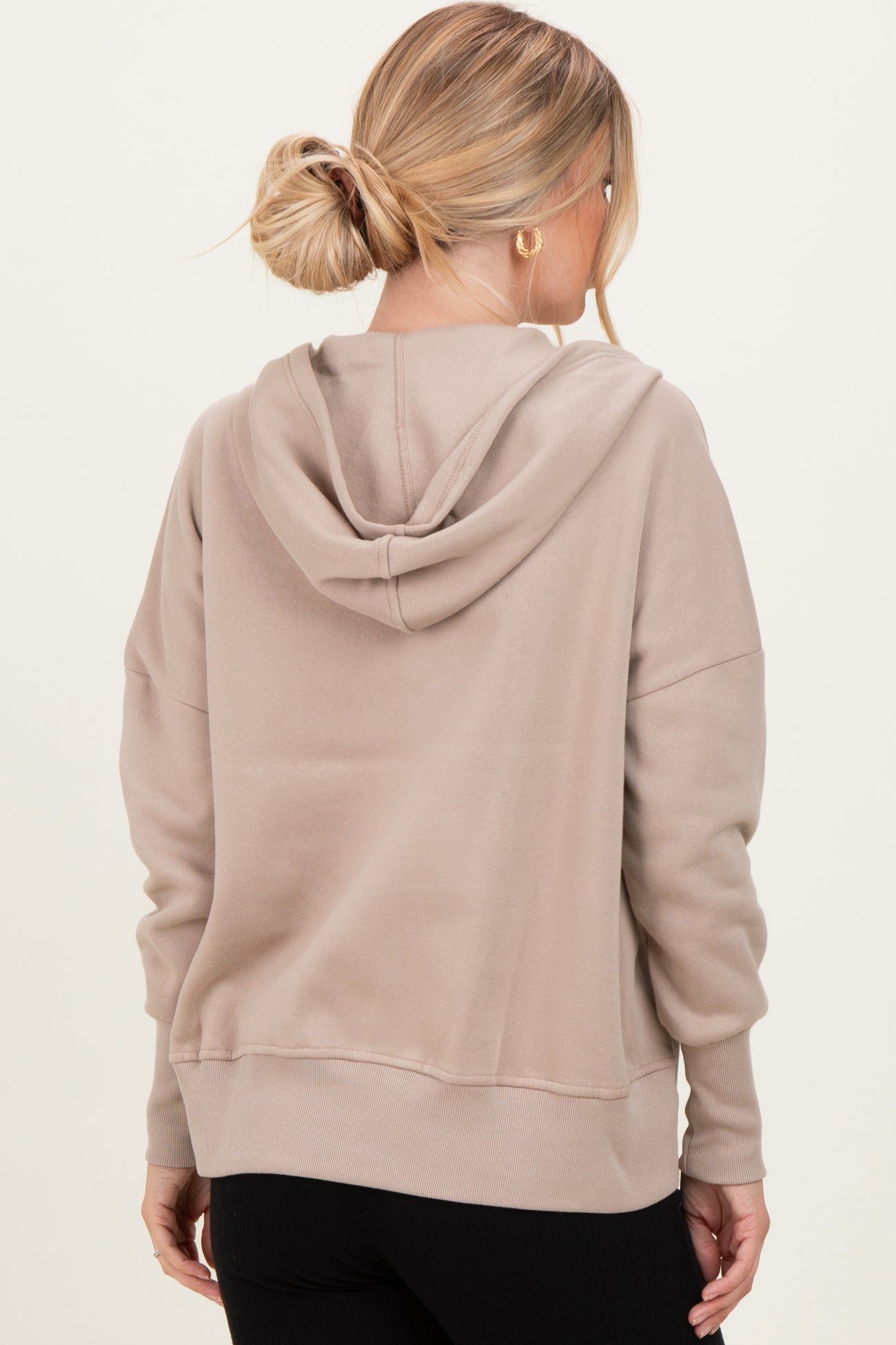 woman wearing a beige oversized hoodie with a back hoodie and ribbed cuffs
