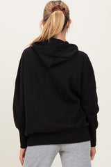 woman wearing a black maternity hoodie with a relaxed fit and hood, seen from the back