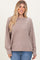 woman wearing a taupe oversized ribbed sweater with long sleeves and a relaxed fit