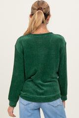 woman wearing a green long sleeve maternity sweater with a relaxed fit and textured pattern from the back
