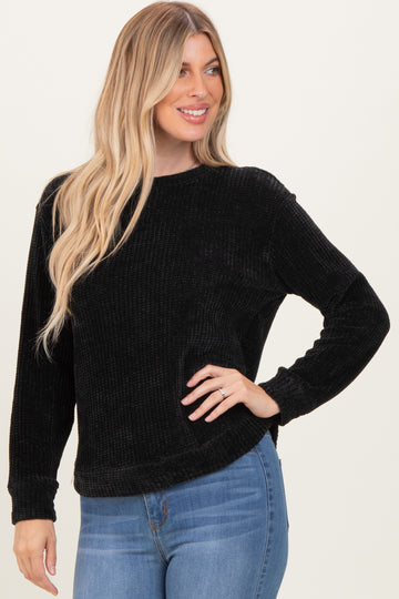 woman wearing a black ribbed long sleeve sweater with a relaxed fit and smiling