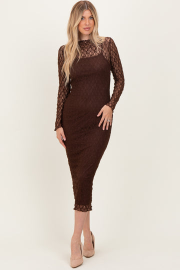 woman wearing a brown lace long sleeve midi dress with a fitted silhouette and a sheer bodice