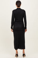 woman wearing a black long sleeve dress with ruching details, showing a sleek silhouette from the back