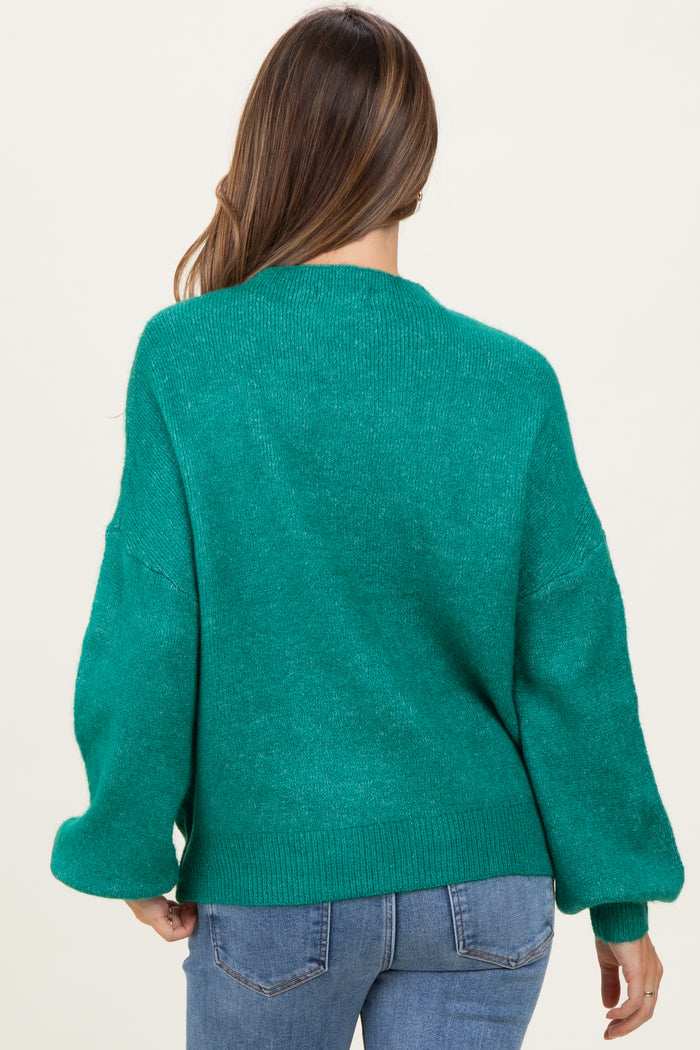 woman wearing a green oversized maternity sweater with loose sleeves, view from the back