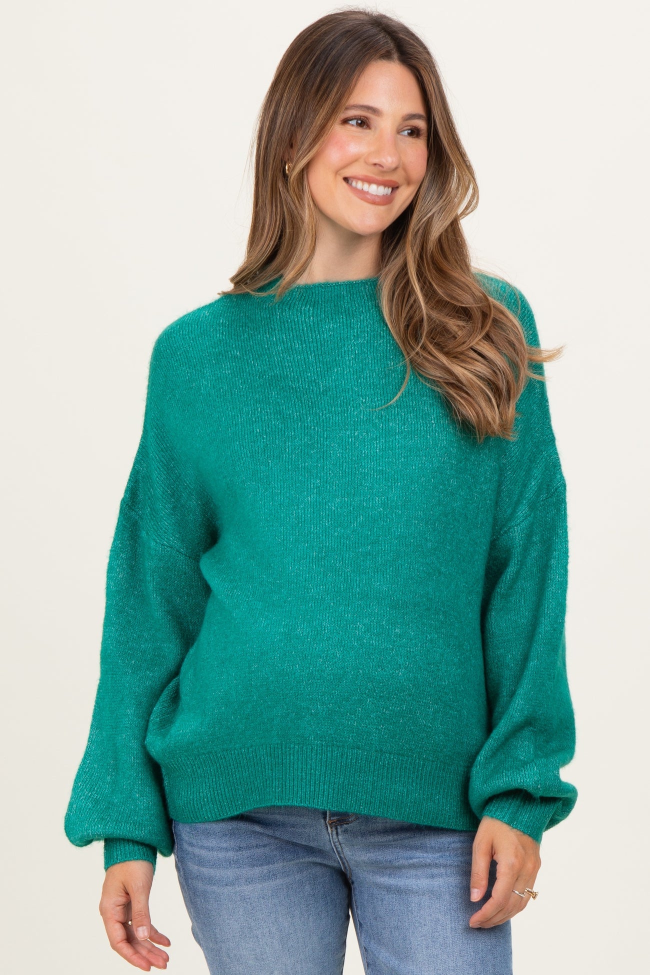 woman wearing a teal oversized maternity sweater with long sleeves and a relaxed fit, showing her baby bump