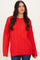 woman wearing a bright red cable knit sweater with a relaxed fit and long sleeves